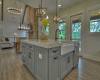 Large open kitchen with quartzite counters and large island with farmhouse sink and lots of cabinet space.